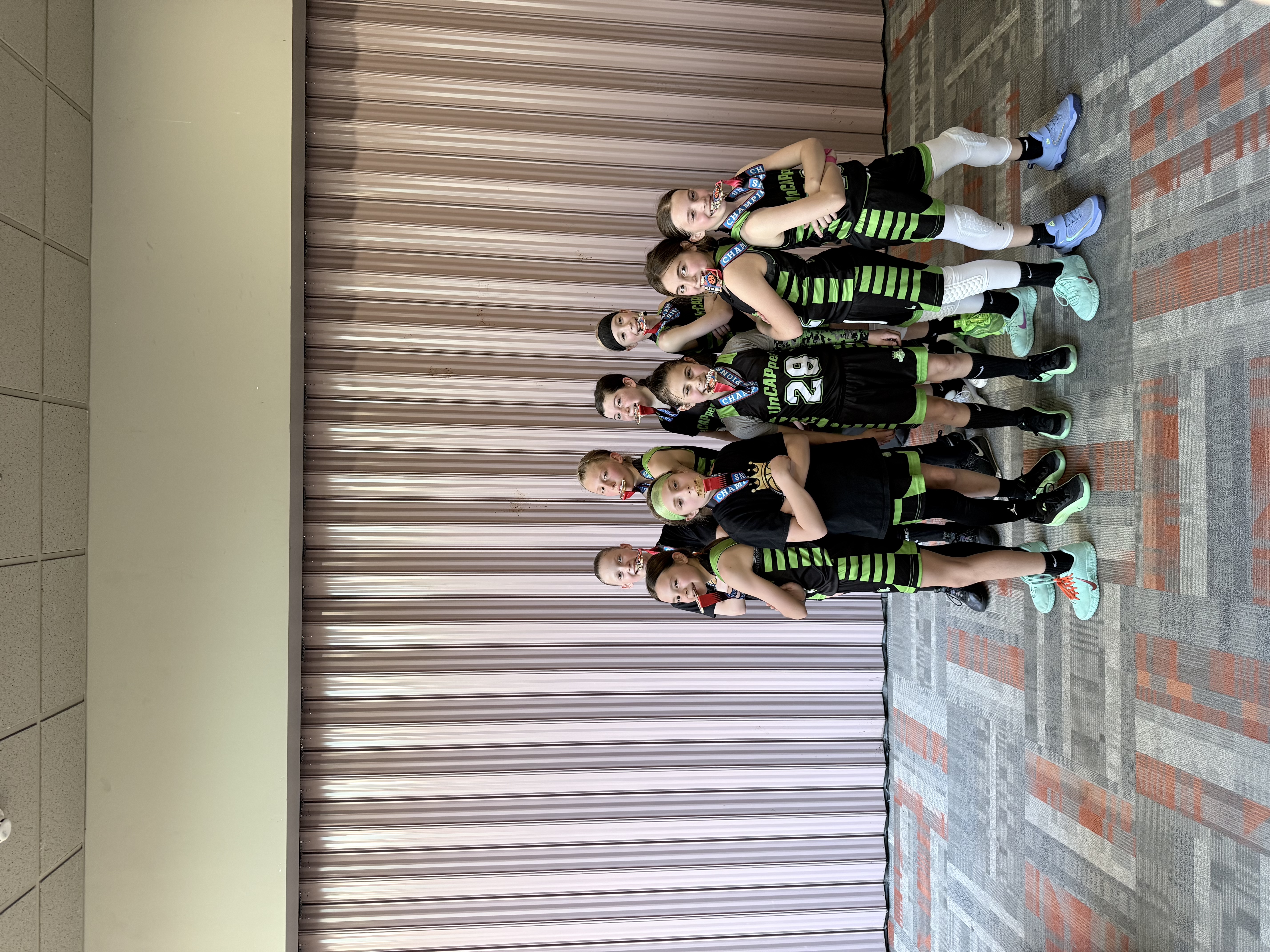 UnCAPped AAU 4th grade girls basketball team poses with championship medals